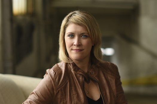 Woman with long blonde and brown hair wearing a leather jacket